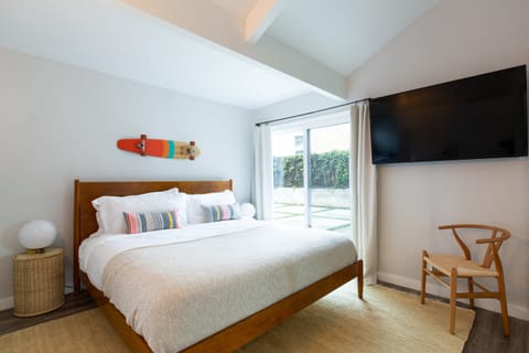 The primary bedroom features an ensuite, TV, and outdoor access.
