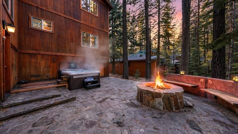 Unwind beneath the pines with a private hot tub, glowing firepit, and cozy mountain ambiance after a day of adventure.