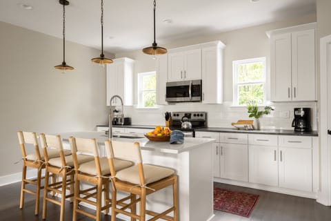 Kitchen features an island with barstool seats and modern appliances.