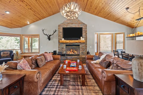 The living room features a large stone fireplace.