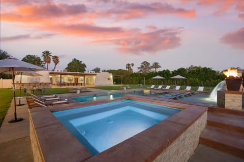 Covered outdoor entertainment area with ambient lighting and a TV.