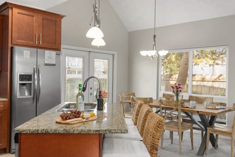 Fully-equipped kitchen with modern appliances and barstool seating at the island counter.