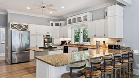 Spacious kitchen with a gas stovetop and barstool seating at the island.