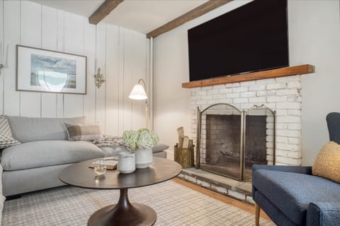 The living room features a fireplace and TV.