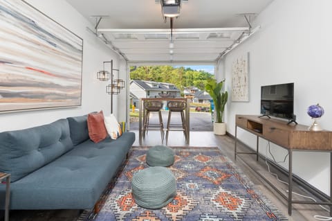 Converted garage lounge features a futon for extra sleeping space, a TV, and a table perfect for games.