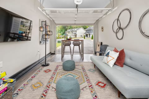 Converted garage lounge features a sleep sofa, TV, and table perfect for games.