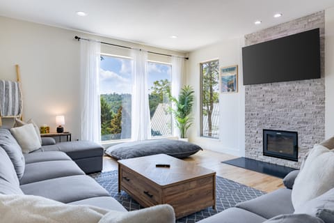 The living room features a fireplace, TV, and a large sectional couch.