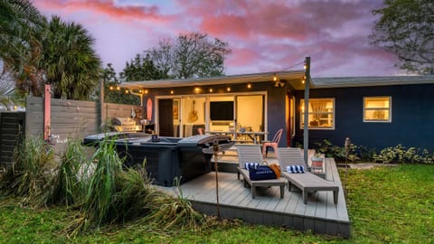 Spacious patio with a hot tub, al fresco dining area, and loungers.