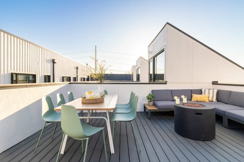 Private rooftop deck features a fire pit, comfortable seating area, and outdoor dining table.