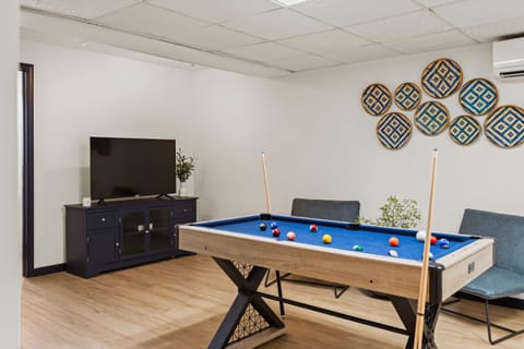 Game room features a pool table, ping pong table, foosball, and TV.