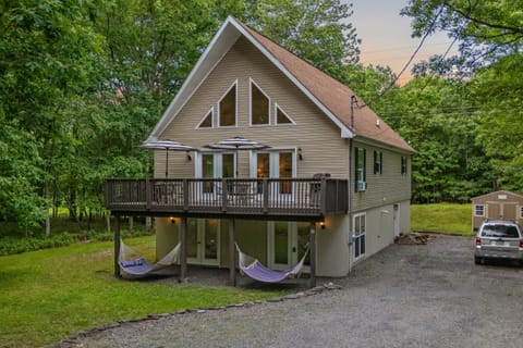 This house with a big deck in the woods exudes a sense of peace and tranquility.