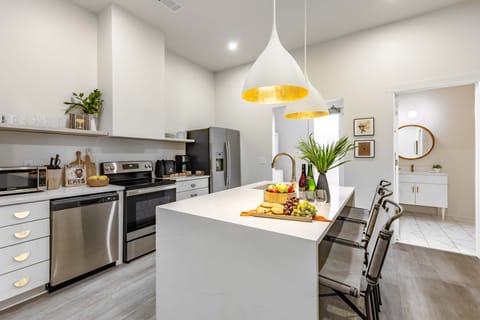 Sleek kitchen features an island with barstool seating.