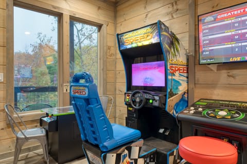 The spacious living room features tall ceilings, a fireplace, a queen sleeper sofa and a TV.