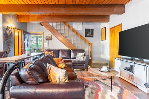 Warm wood beams, rich leather seating, and a cozy open layout create the perfect mountain gathering space for movie nights and relaxed evenings in.