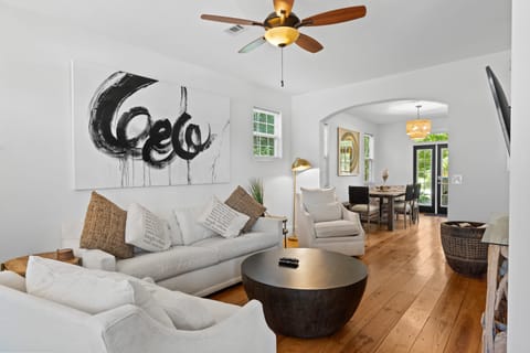 Living room features a flat-screen TV, a ceiling fan, and plush seating.