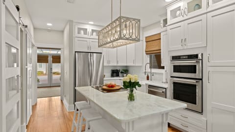 Modern kitchen featuring a marble island and stainless steel appliances.