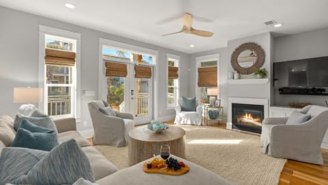 Bright living room with a fireplace, comfortable seating, and coastal decor.