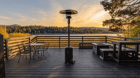 Wide lakefront deck glowing in the evening light, set with plenty of space to dine, gather, and take in the view.