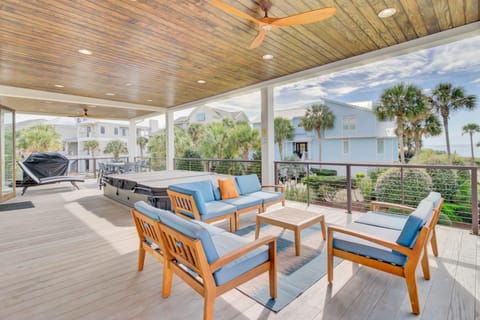 Spacious covered deck with seating areas and a hot tub.