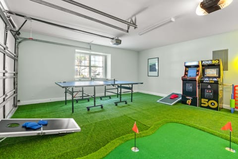 Garage features a putting green area, arcade games, cornhole and a ping pong table.