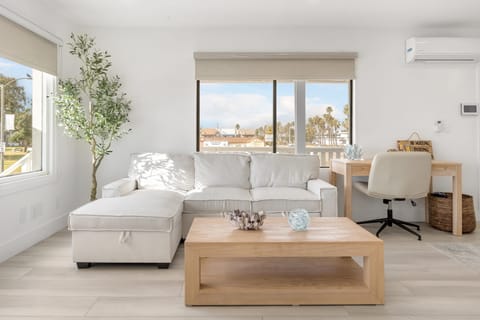 Unwind in the inviting living area with a queen sofa bed and designated work area. (Sunset Surf)