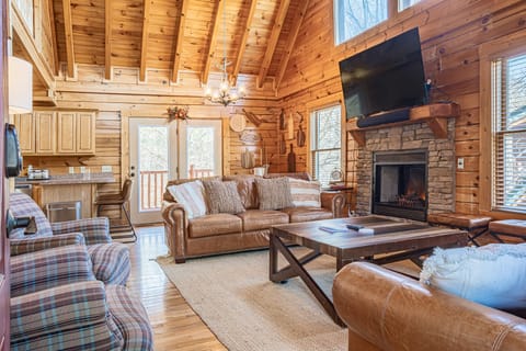 Cozy living room with a comfy couch, warm fireplace, and TV—perfect for relaxing after a day of adventure!