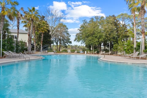 Resort-style pool surrounded by lush greenery.