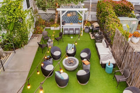 Lush backyard oasis with a cozy pergola and seating area.