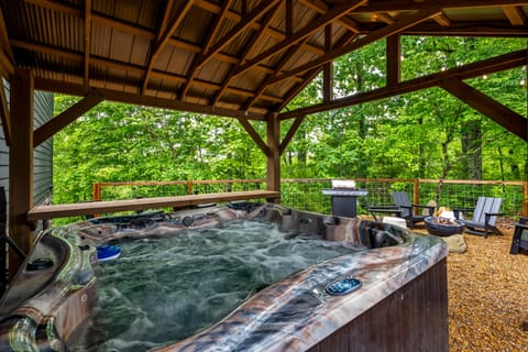 Spacious covered 7-person hot tub area surrounded by nature.