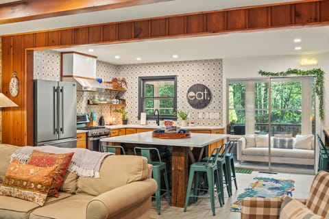 Fully equipped kitchen with a center island table for a dining experience.