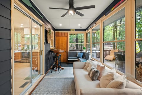 Sunroom with lounge seating and expansive windows.
