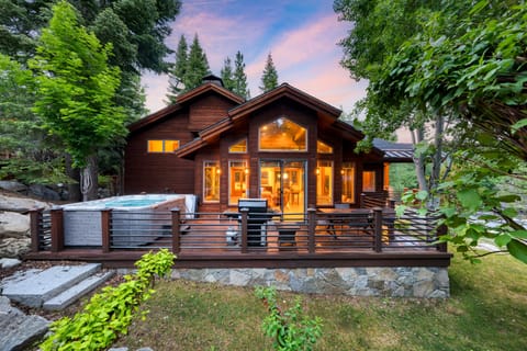 Spacious exterior deck featuring a private hot tub, grill, and outdoor dining area