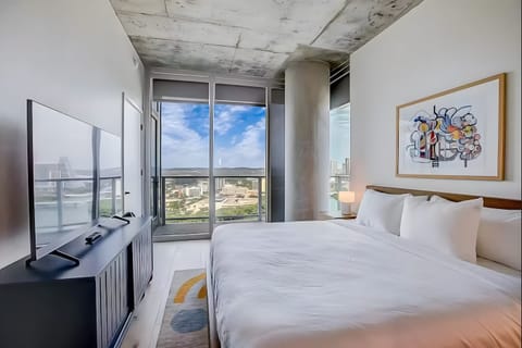 Primary bedroom features a king bed, TV, balcony, and ensuite bathroom.