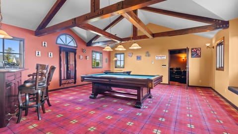 Fun-filled game room featuring a pool table, poker table, and a stylish bar.