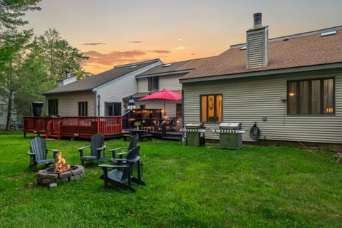 Spacious, lush backyard with a firepit, two grills, and plenty of outdoor seating for relaxing or dining al fresco.
