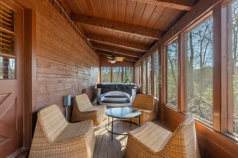 Screened in porch features seating and a hot tub. (Dudley II)