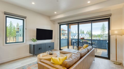 Bright living area with balcony access and smart TV.