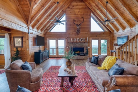 Bright and airy main level living room with plush seating, fireplace, and a TV.