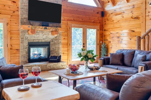 Living room with cozy seating, a fireplace, TV, and easy access to the balcony for indoor-outdoor relaxation. (Big Bear Cove)