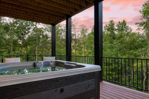 Covered hot tub with sunset mountain views.