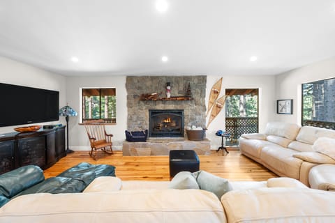 Open-concept living area with a stone fireplace and cozy seating.