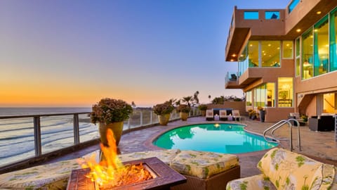 Lounge poolside by the fire pit with stunning ocean views.