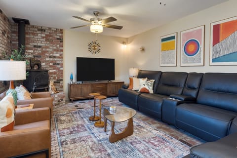 Entertainment space with fireplace, reclining sofas, flat-screen TV, and a jukebox.