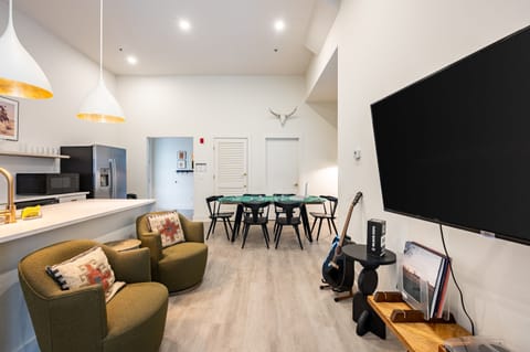 Cozy living room with plush seating, TV, and guitar. (Outrider 107)