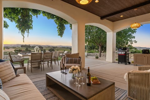 Covered lounge with stylish lighting, BBQ grill, and al fresco dining.