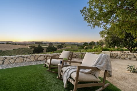 Lounge chairs at sunset overlooking vines.