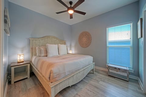The primary bedroom features a king bed with a ceiling fan and natural light.