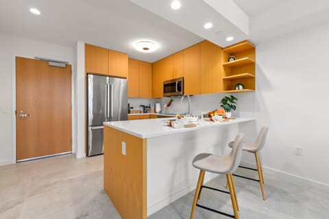 Prepare meals with ease in this bright, modern kitchen featuring sleek countertops and stainless steel appliances.
