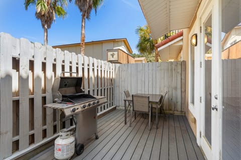 A private patio with a gas grill and outdoor seating, perfect for a sunny day barbecue.