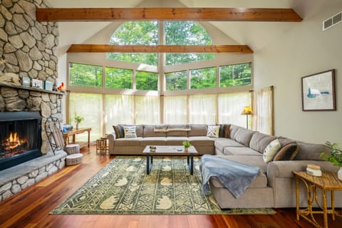 Cozy up on the large sectional in the living room, complete with a fireplace, high ceilings, and plenty of space to unwind.